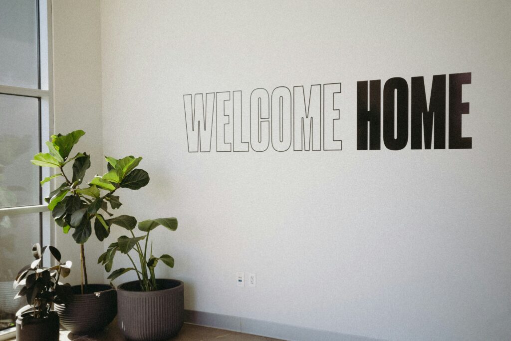 A tenant welcome package sign attached to a beige wall beside a potted plant